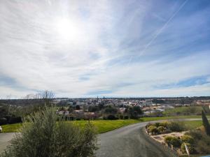 a road leading down to a town under a cloudy sky at Maison Toussaint in Saint-Laurent-sur-Sèvre