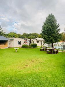 a park with two picnic tables and a tree at Munisa Guest House in Johannesburg