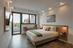 a bedroom with a large bed and a large window at Zed Smart Property Airport by Airstay in Spáta