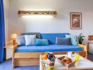 Sofá azul en la sala de estar con mesa en Studio Lunik Orion-12 by Interhome, en Le Corbier