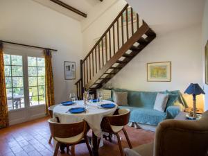 uma sala de estar com uma mesa e um sofá azul em Holiday Home Les Mas de Pramousquier-2 by Interhome em Rayol-Canadel-sur-Mer