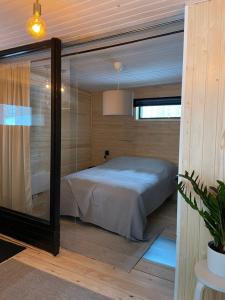 ein Schlafzimmer mit einem Bett in einer Glaswand in der Unterkunft Mokki kesämökki in Jyväskylä