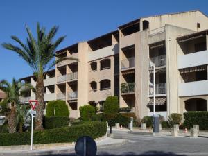 a building with a palm tree in front of it at Apartment Les Aigues Marines-36 by Interhome in La Madrague