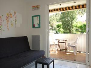 a living room with a couch and a patio with a table at Apartment Les Aigues Marines-36 by Interhome in La Madrague