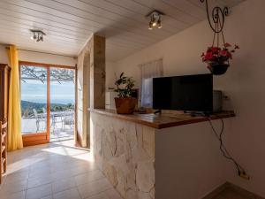 a living room with a tv and a stone fireplace at Holiday Home Campestra by Interhome in Coti-Chiavari