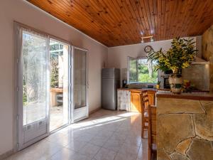 a kitchen with a large sliding glass door and a refrigerator at Holiday Home Campestra by Interhome in Coti-Chiavari