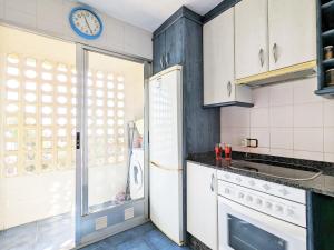a kitchen with a refrigerator and a clock on the wall at Apartment Coblanca XVI by Interhome in Cala de Finestrat