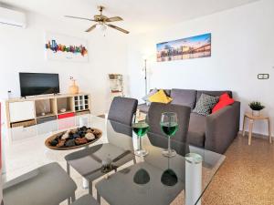 a living room with a couch and a table with wine glasses at Apartment Coblanca XVI by Interhome in Cala de Finestrat