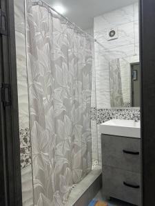 a bathroom with a shower curtain and a sink at Ultra Hostel in Dushanbe
