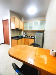 a kitchen with a wooden table and a wooden counter top at [HERITAGE 9] HOMESTAY Studio 4Pax, FREE WIFI in Seri Kembangan