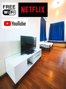 a living room with a tv and a white entertainment center at [HERITAGE 9] HOMESTAY Studio 4Pax, FREE WIFI in Seri Kembangan