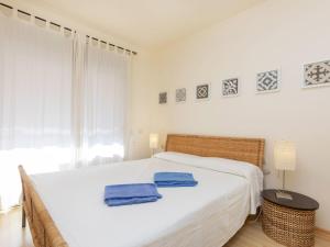 um quarto com uma cama branca com duas toalhas azuis em Apartment Jardins Sa Boadella by Interhome em Lloret de Mar