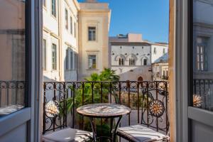 a balcony with a table and chairs on a balcony at Ortigia ART & DesiGn, Parking , Smartworking in Syracuse