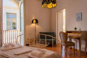 a bedroom with a bed and a table and a desk at Ortigia ART & DesiGn, Parking , Smartworking in Siracusa