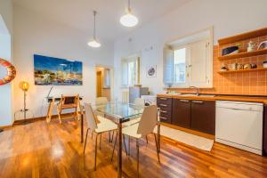 a kitchen and dining room with a glass table and chairs at Ortigia ART & DesiGn, Parking , Smartworking in Syracuse