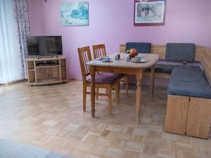 uma sala de estar com uma mesa e um sofá em Holiday Home Strandwinkel by Interhome em Norddeich