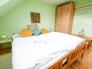 ノルトダイヒにあるHoliday Home Strandwinkel by Interhomeのベッドルーム1室(白い大型ベッド1台、オレンジと青の枕付)
