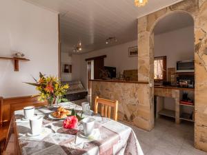 a dining room with a table with flowers on it at Holiday Home Campestra by Interhome in Coti-Chiavari