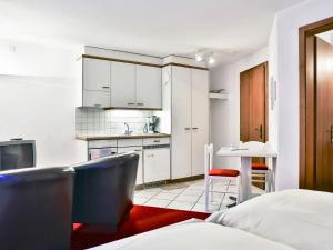 uma pequena cozinha com armários brancos e uma mesa em Apartment Chalet Abendrot-4 by Interhome em Grindelwald