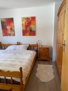 a bedroom with a bed and a nightstand and paintings at Apartment Eva by Interhome in Schmitten