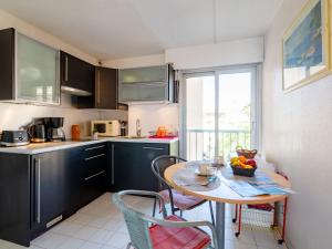 una cocina con una mesa con un bol de fruta. en Apartment Le Capitole-3 by Interhome en Fréjus