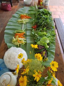 een tafel met groenten en bloemen op een bananenblad bij Midori Coffee Farm in Da Lat