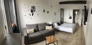 ein Wohnzimmer mit einem Sofa und einem Bett in der Unterkunft Hotel de la Place in Loyettes