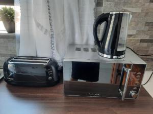 a microwave and a toaster and a toaster oven at Cottage @19th in Pretoria
