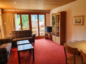 uma sala de estar com um sofá e uma mesa em Apartment Chalet Abendrot-25 by Interhome em Grindelwald