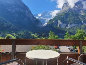 uma mesa numa varanda com vista para as montanhas em Apartment Chalet Abendrot-7 by Interhome em Grindelwald