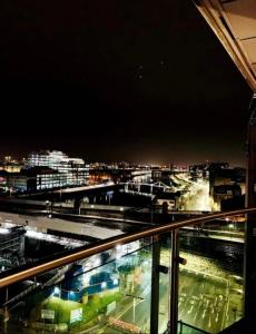 a view of a city at night from a balcony at Designer Penthouse with Riverviews - G1 Glasgow City Centre, 3 Bedrooms, 2 Bathrooms, 1 Living room / Kitchen. Full Floor, Wrap Around Terrace, Panoramic Views, Off Central Station / Buchanan Street in Glasgow