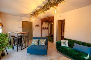 a living room with a green couch and a table at Appartement Romance Florale Troyes in Troyes