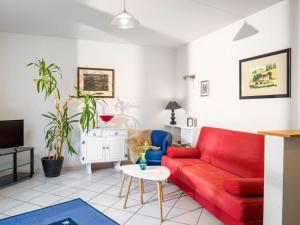 ein Wohnzimmer mit einem roten Sofa und einem Tisch in der Unterkunft Apartment Kiefernweg by Interhome in Ramersbach