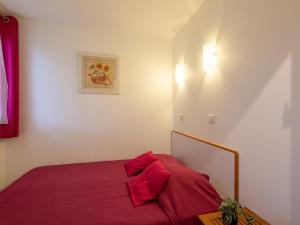 a bedroom with a bed with red sheets at Apartment Les Coteaux de la Nartelle-17 by Interhome in Sainte-Maxime