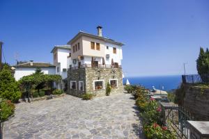 a large white building on a hill next to the ocean at Guesthouse Papagiannopoulou in Zagora