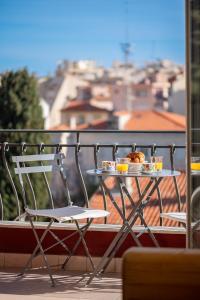 un tavolo con un piatto di cibo su un balcone di La Fabrique à Poupées - Chambres de charme au coeur de Menton a Mentone