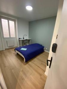 a bedroom with a blue bed and a desk at Appartement 5 chambres tous conforts - WIFI - TV in Saint-Étienne