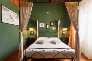 a bedroom with a bed with a green wall at Firenze Rentals Corso 12 in Florence