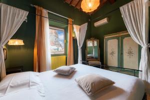 1 dormitorio con cama blanca y ventana en Firenze Rentals Corso 12, en Florencia