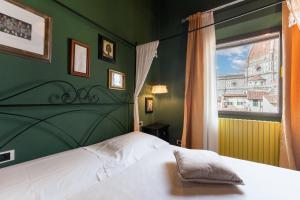 a bedroom with a white bed and a window at Firenze Rentals Corso 12 in Florence
