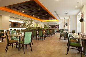 un comedor con mesas y sillas en un restaurante en Lemon Tree Premier, Ulsoor Lake, Bengaluru, en Bangalore