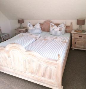 een groot wit bed met kussens erop bij Ferienwohnung Joanna in Norddeich