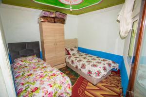 1 dormitorio pequeño con 2 camas y vestidor en auberge agla 1, en Ouazzane