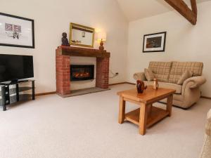 a living room with a couch and a fireplace at The Old Coach House in Pickering