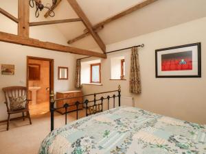 a bedroom with a bed and a chair at The Old Coach House in Pickering