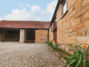 a brick building with a stone wall and a courtyard at The Old Coach House in Pickering