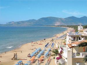 a beach with chairs and umbrellas and people on it at Apartment Costa di Kair ed Din-6 by Interhome in Sperlonga