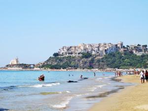 a beach with a bunch of people in the water at Apartment Costa di Kair ed Din-6 by Interhome in Sperlonga