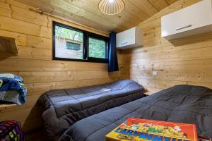 a room with two beds in a log cabin at Cabane ''Robinson'' dans les arbres de Nature et Océan à côté de la plage in Messanges
