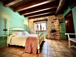 a bedroom with a bed and a stone wall at Agroturismo el Encuentro in Leza